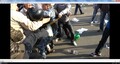 Невидимый человек бьет ногой по шлему Троерина, шлем перекатывается через руки людей